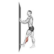 Miniatura de Estiramiento de gemelos empujando con las manos contra la pared